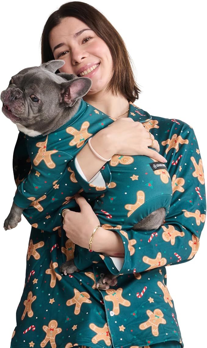 A woman holding a bulldog both wearing matching patterned clothing