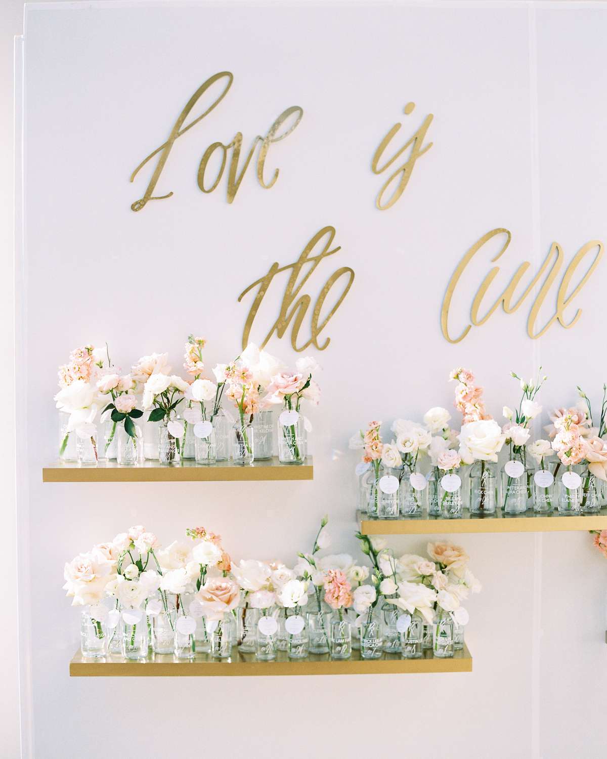 short stemmed floral arrangements in glass jars on floating shelves