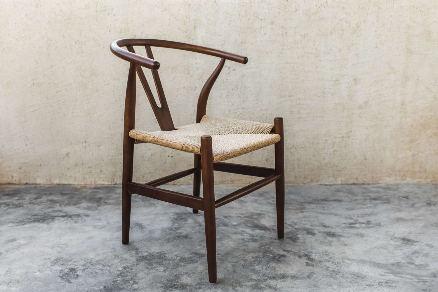A wooden chair with a woven seat and a curved backrest
