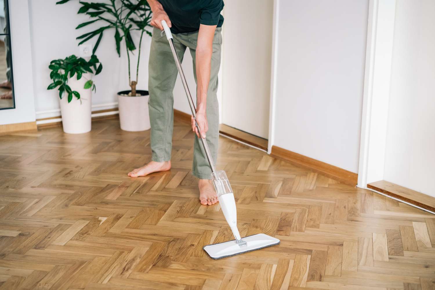Man mopping and cleaning hardwood floor