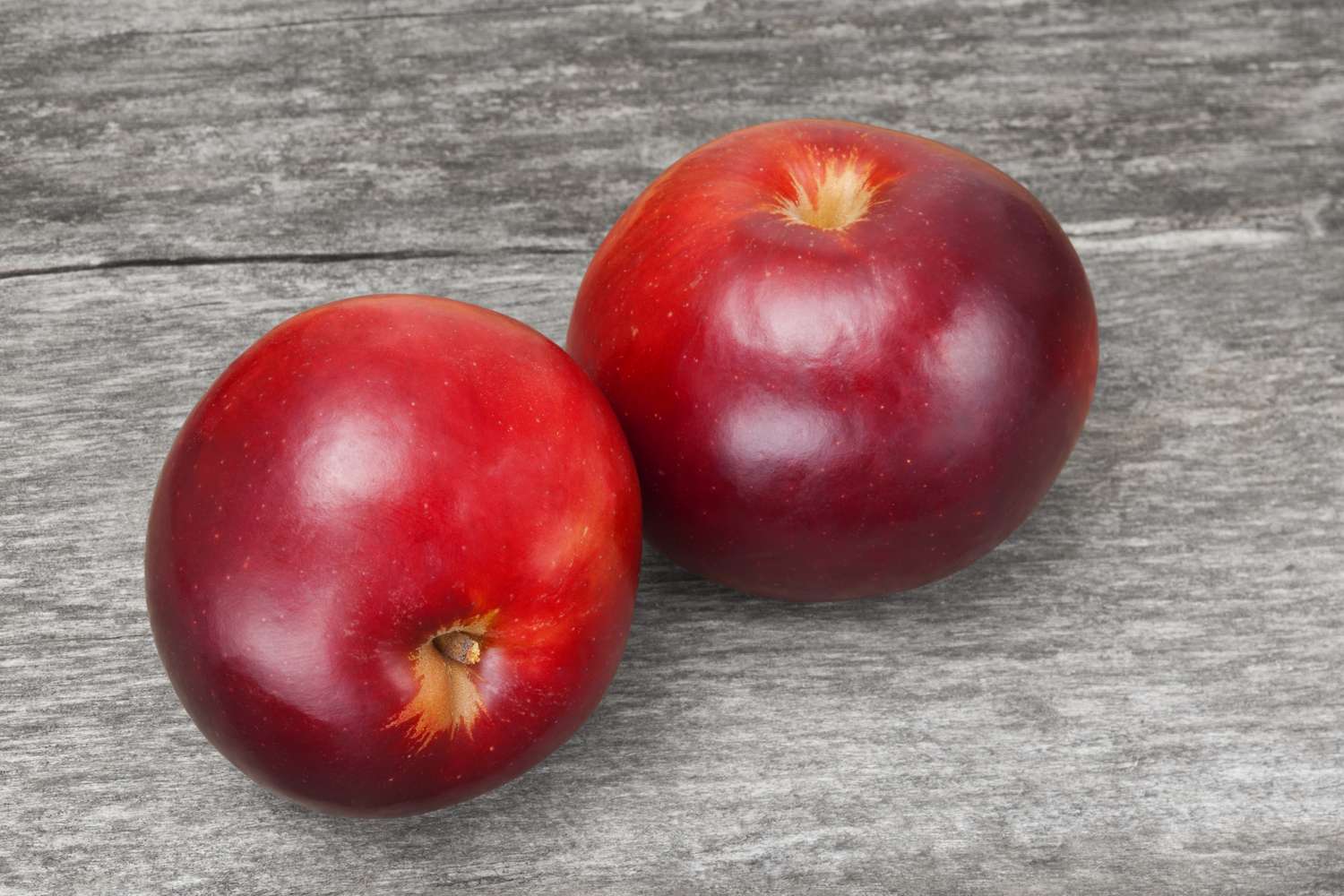 Two apples on a wooden surface