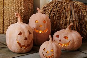 Terracotta jackolantern decorations on a patio displayed with a woven pumpkin for a festive arrangement