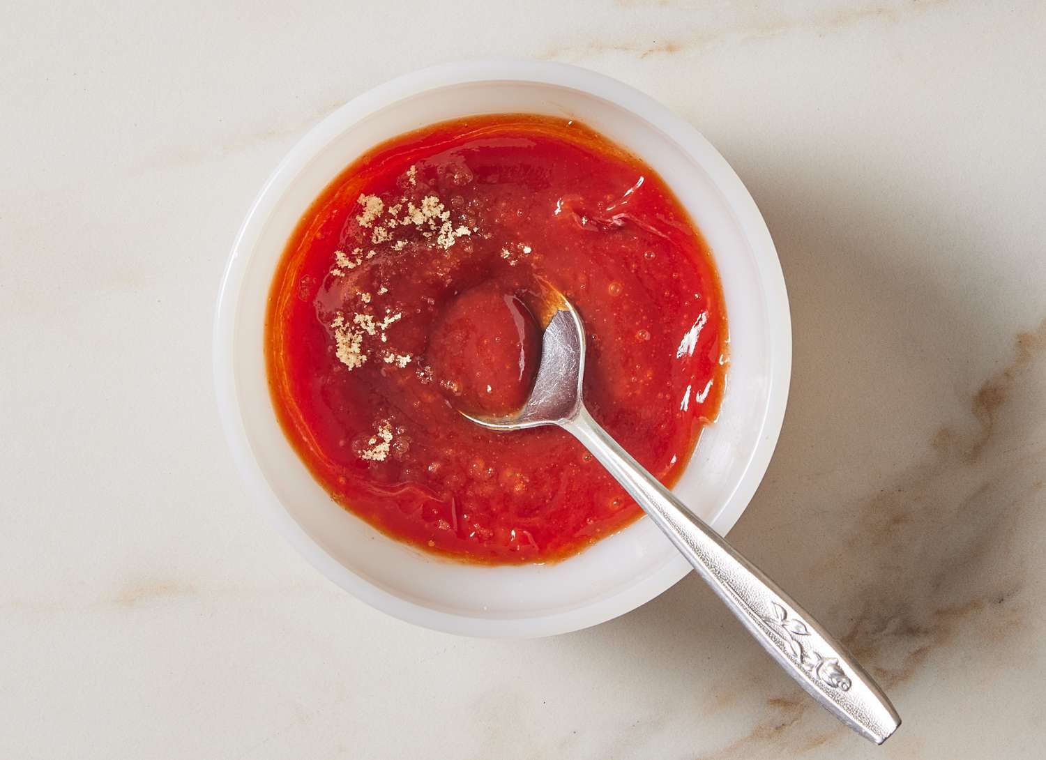 ketchup and spices with a spoon in a small bowl