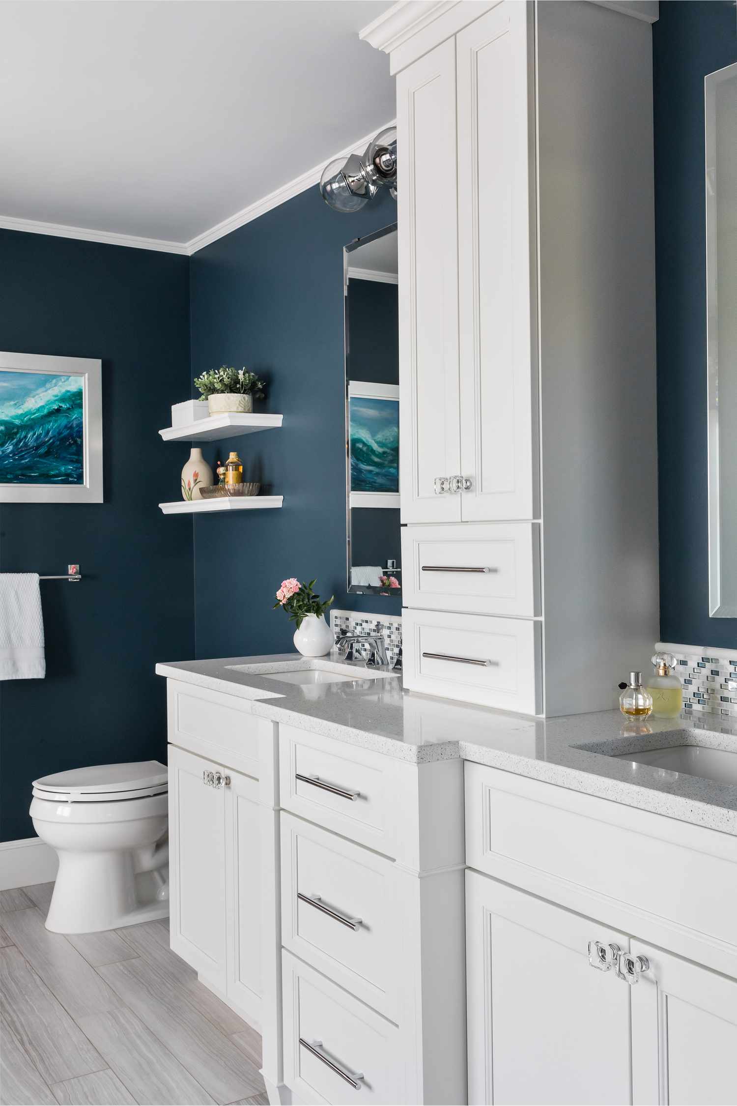 a blue bathroom with built-in white shelves