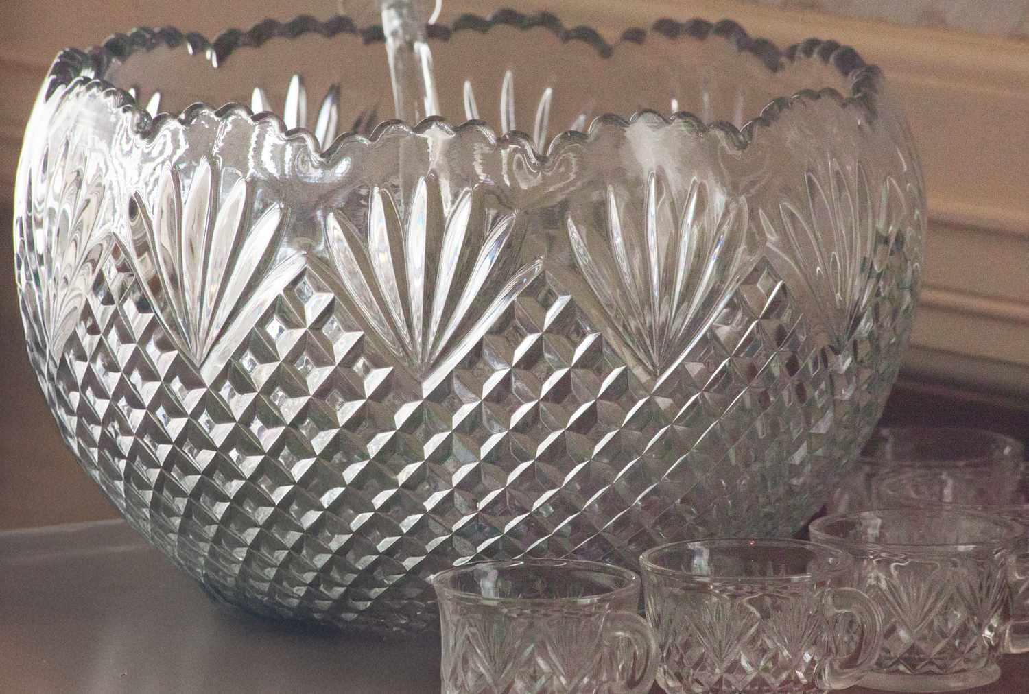 Crystal punch bowl with matching cups arranged around it