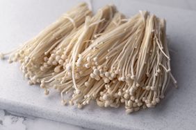 enoki mushrooms on cutting board
