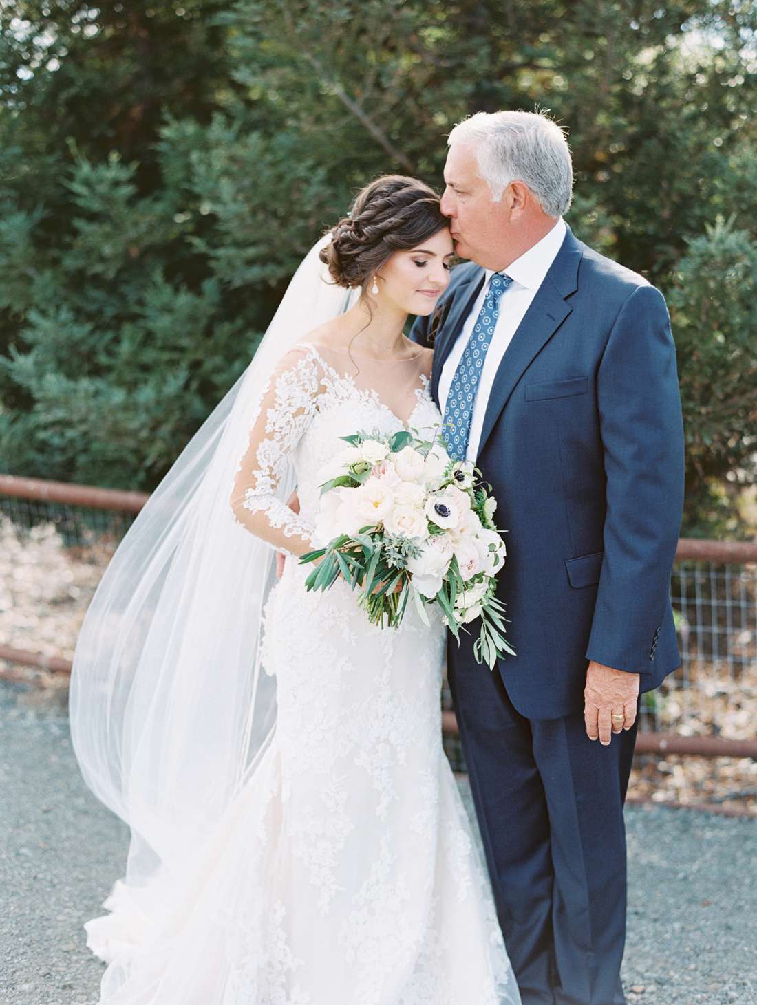 father of the bride wearing a navy blue suit with a blue printed tie