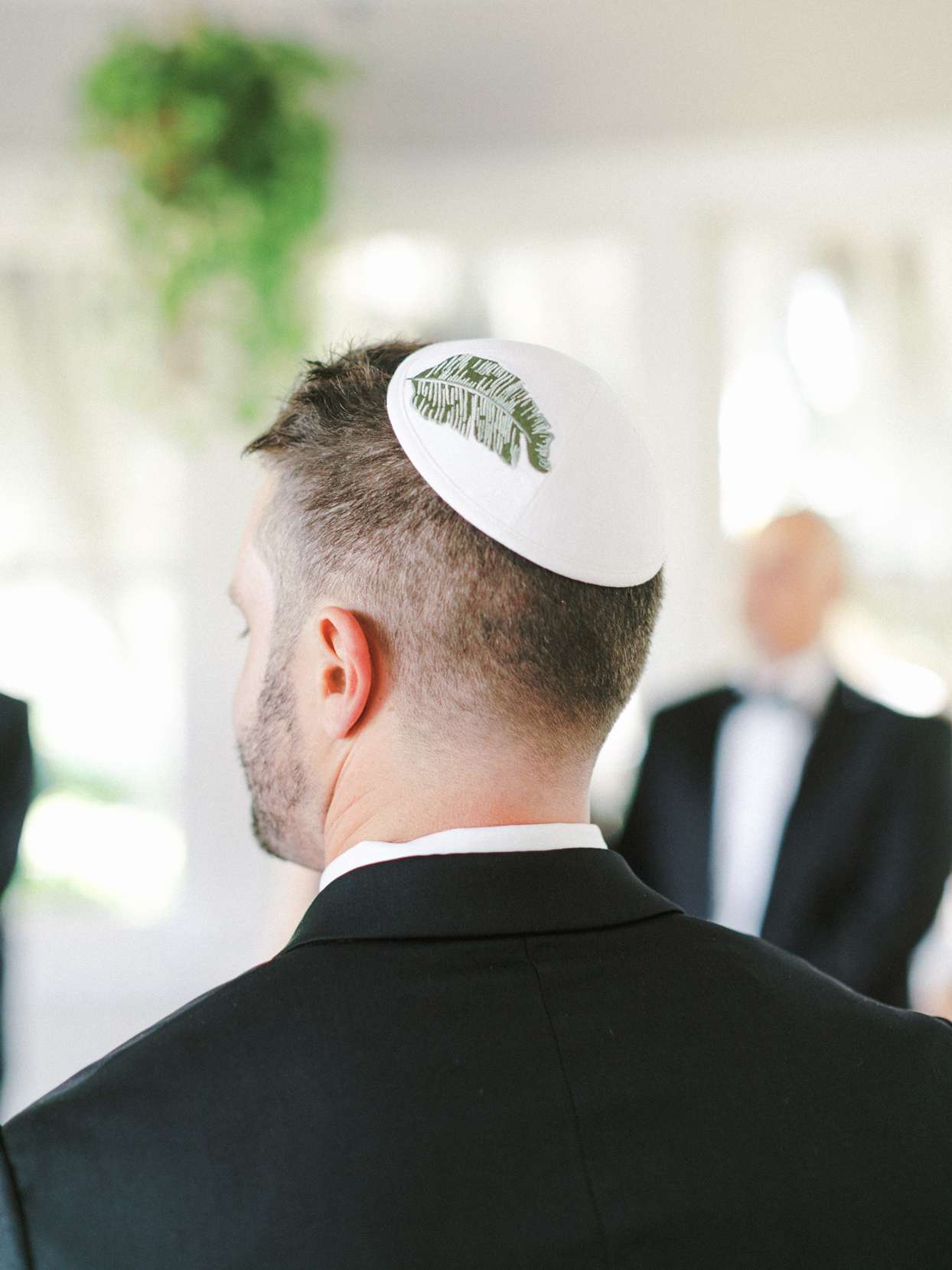 groom wearing yarmulke adorned with banana leaf