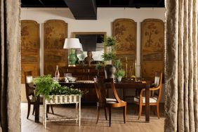 Elegant showroom with a dining table chairs plants and decorative panels