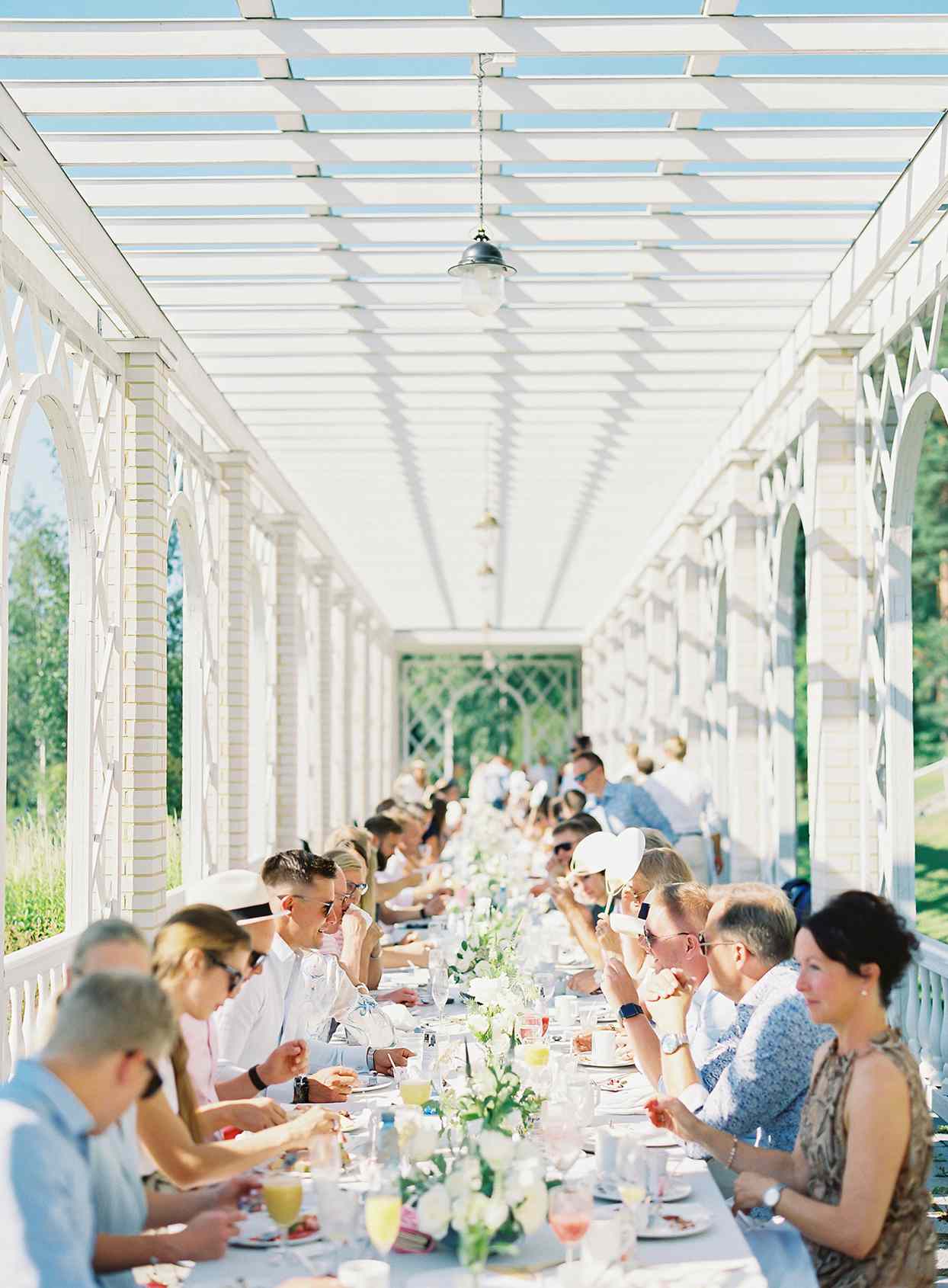 laura alexander wedding brunch guests at long outdoor table