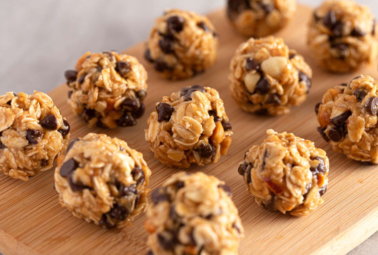 Protein balls with oats nuts and chocolate chips arranged on a wooden surface