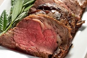 roast prime rib on a white plate with green garnish