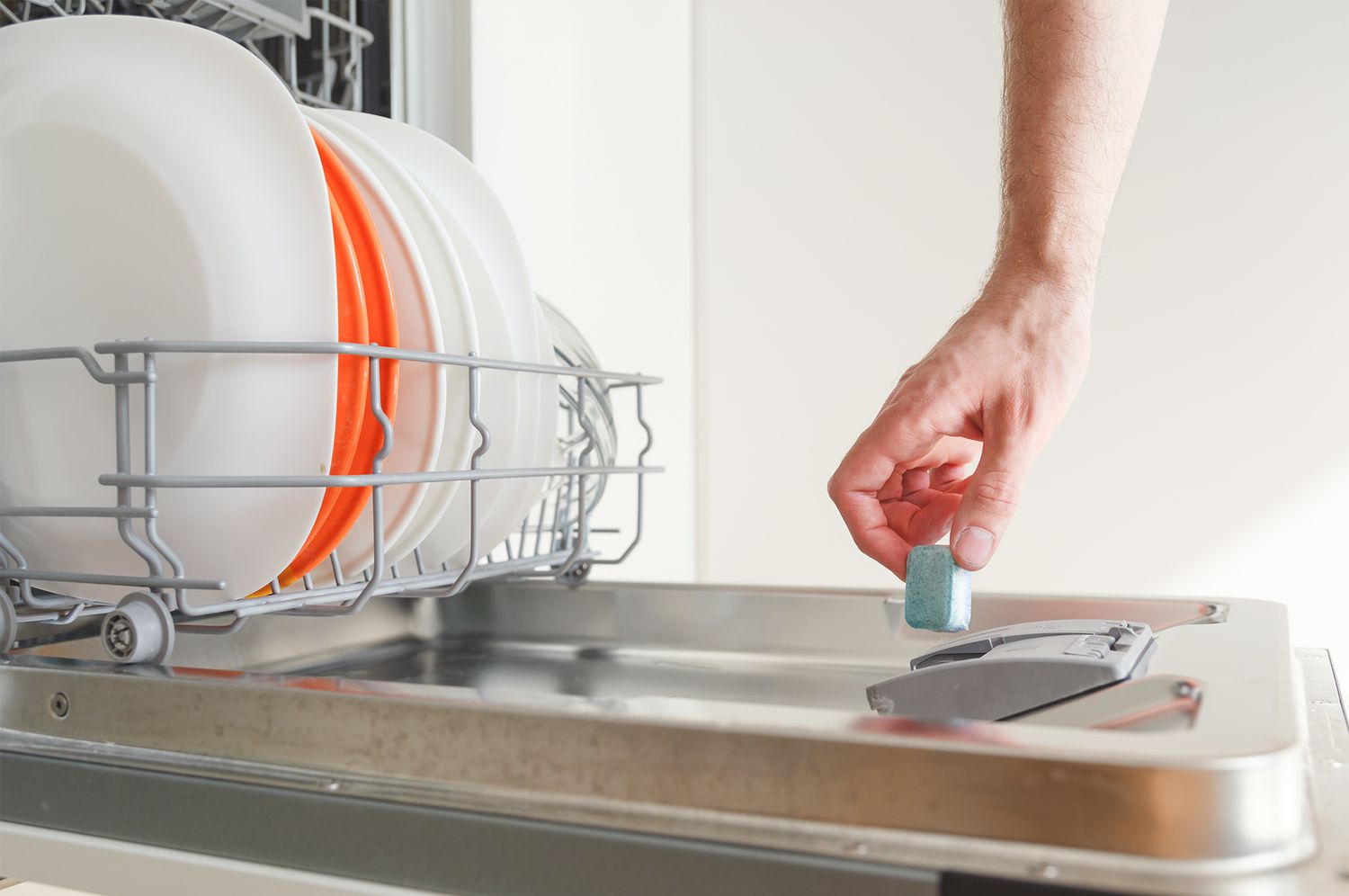 Man adding detergent pod to dishwasher