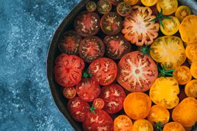 A variety of sliced tomatoes arranged in a bowl
