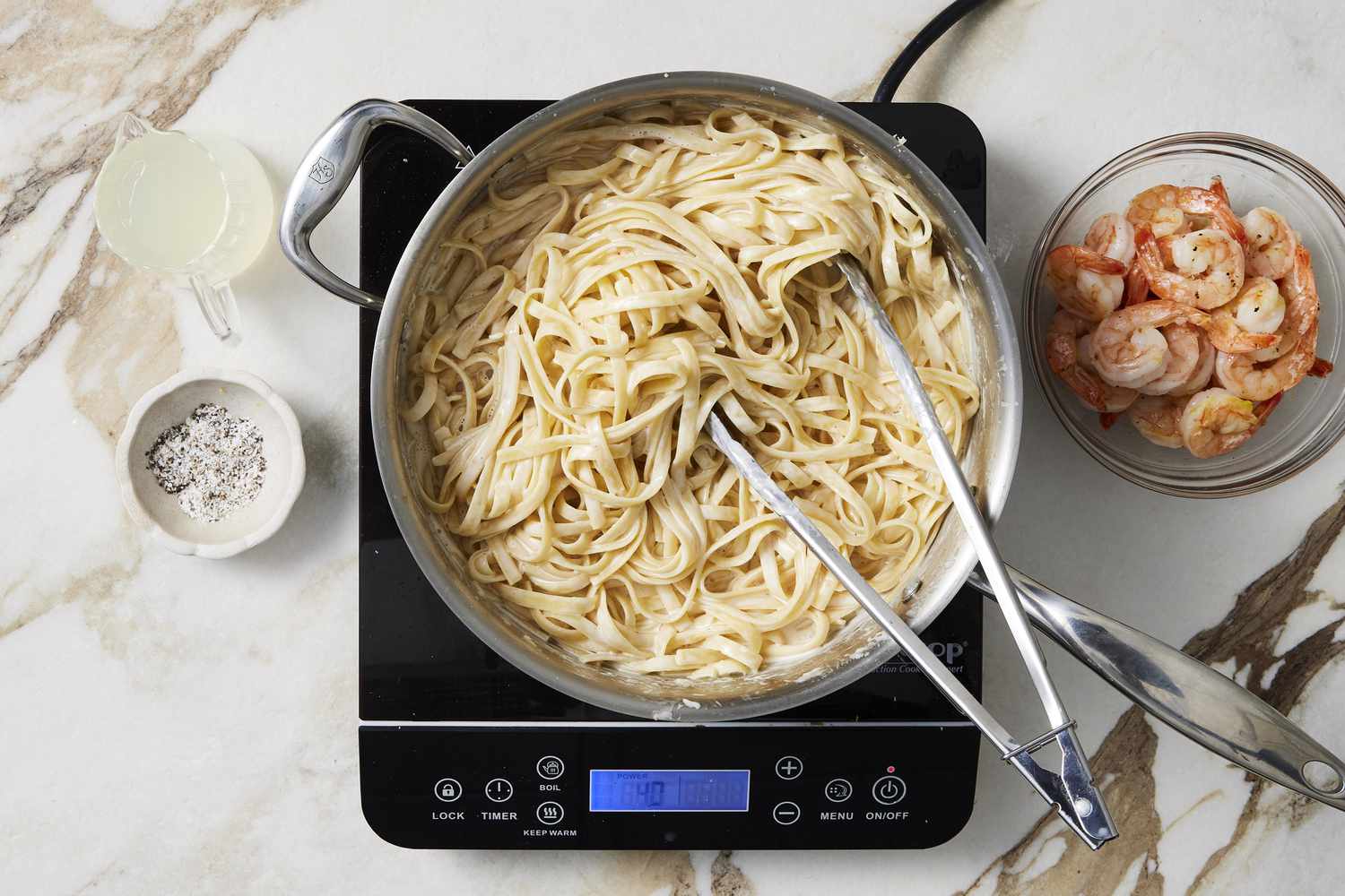 Cooked pasta in pot next to shrimp