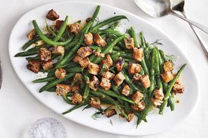 Plate of green beans topped with croutons