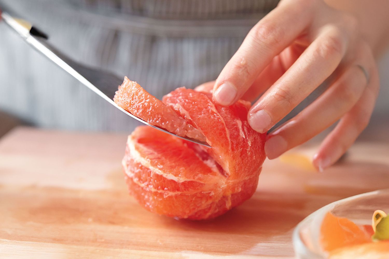 Person cutting a grapefruit