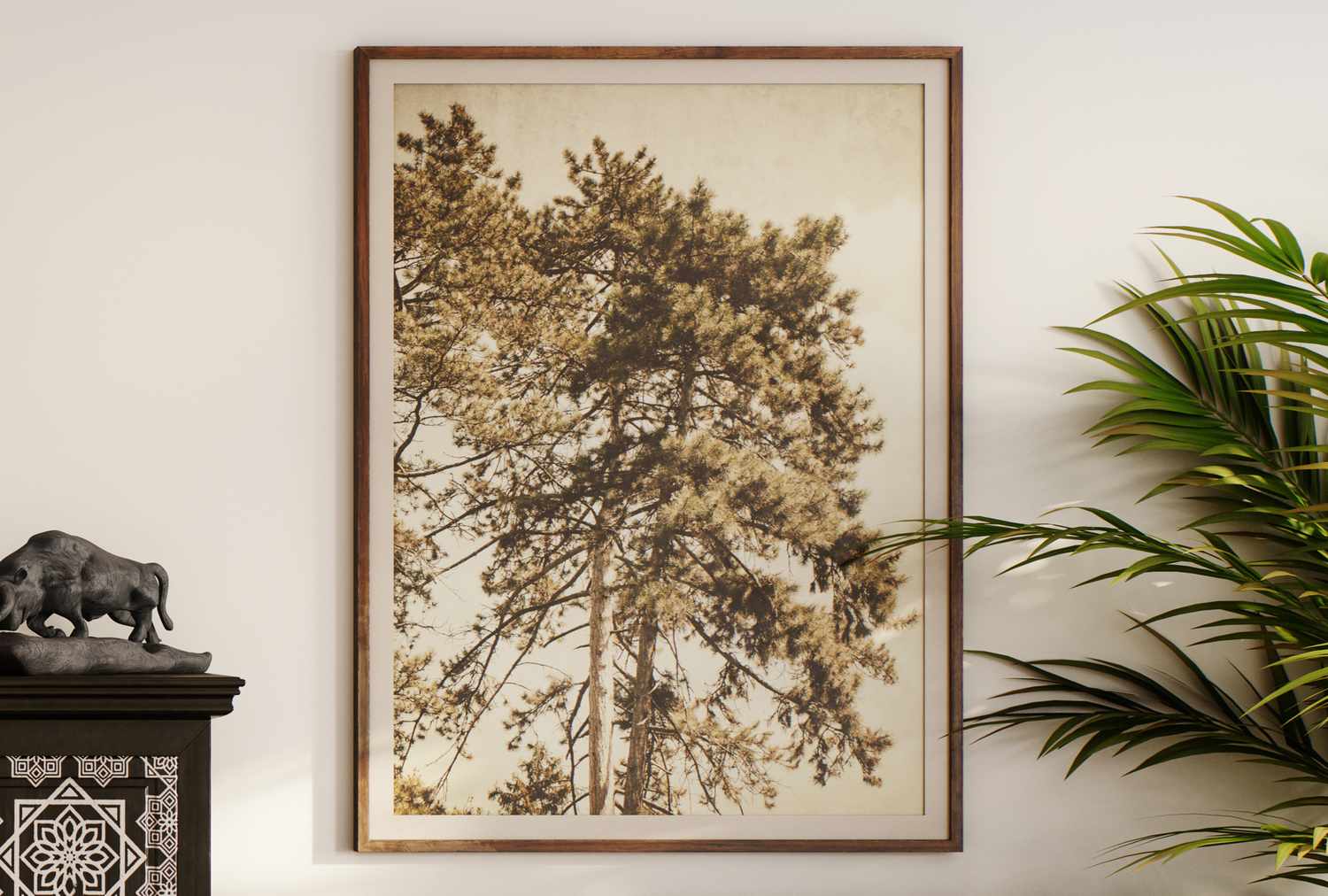 Framed artwork of a tree displayed on a wall with surrounding decor and plant
