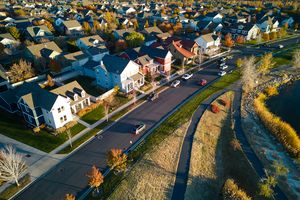 A residential neighborhood with houses roads and a visible water body or park on the side