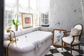 Luxurious bathroom featuring a freestanding bathtub, elegant decor, and framed artwork