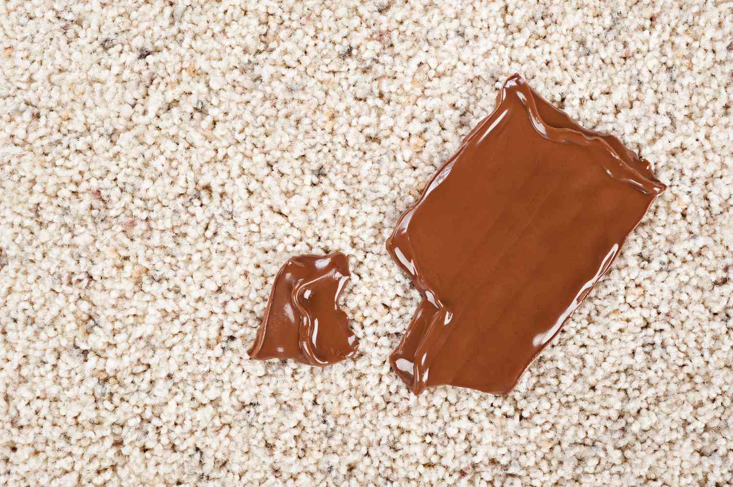 A melting chocolate candy bar dropped on a newly carpeted floor.