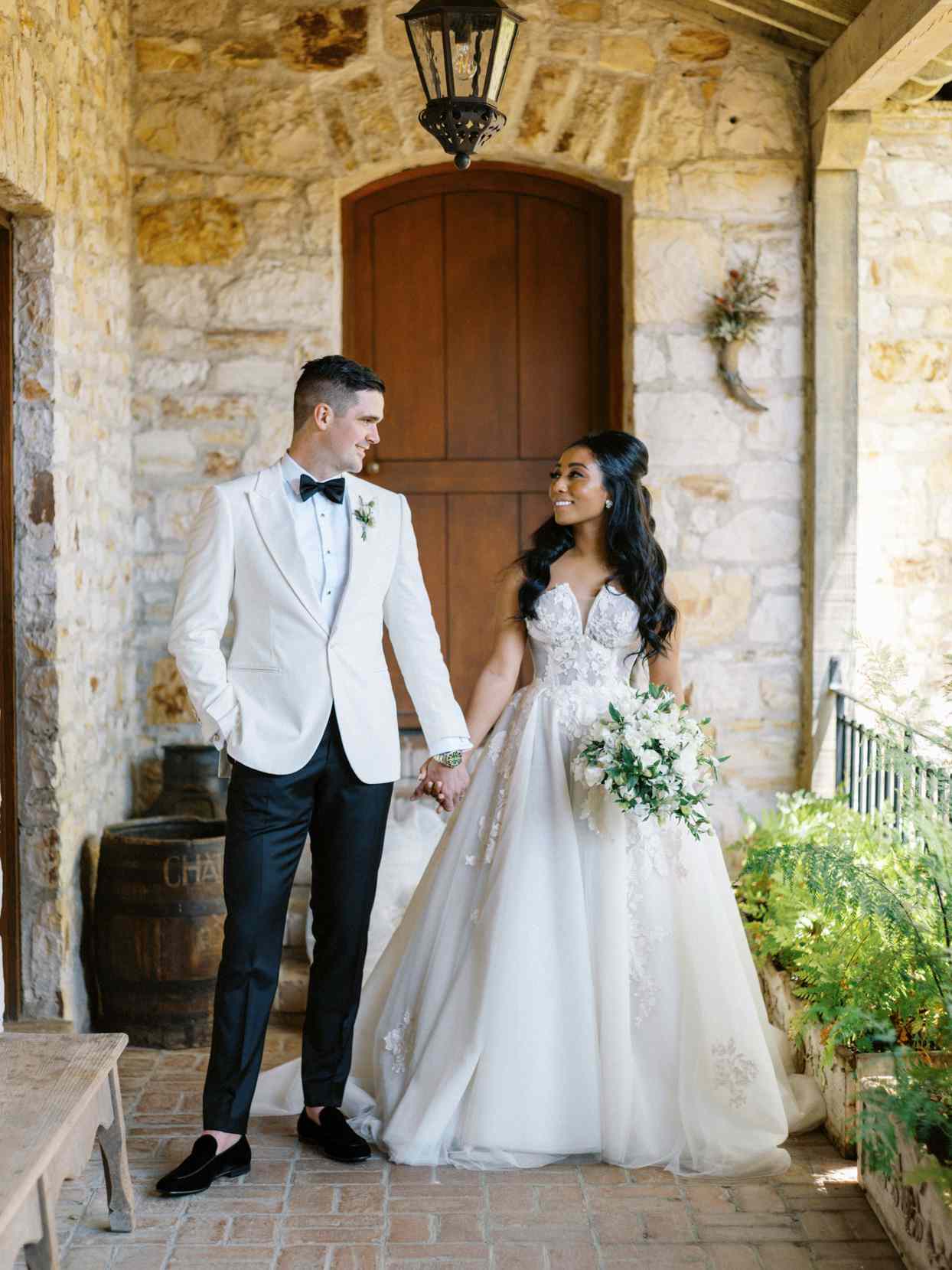 bride and groom in front of stone building