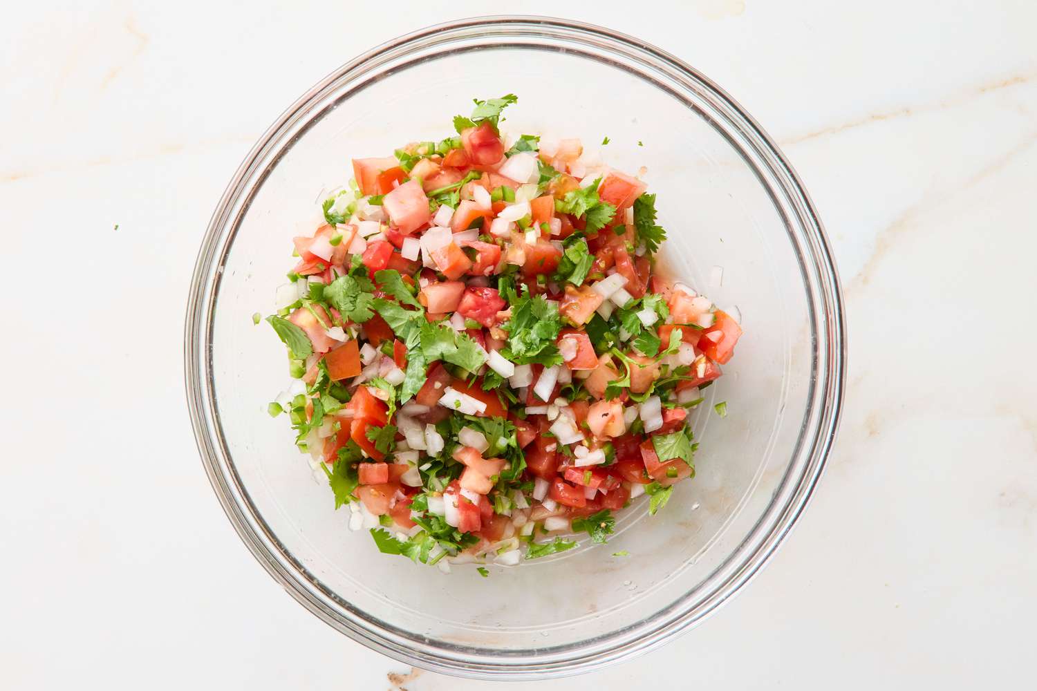 Bowl of freshly made salsa with diced ingredients and herbs
