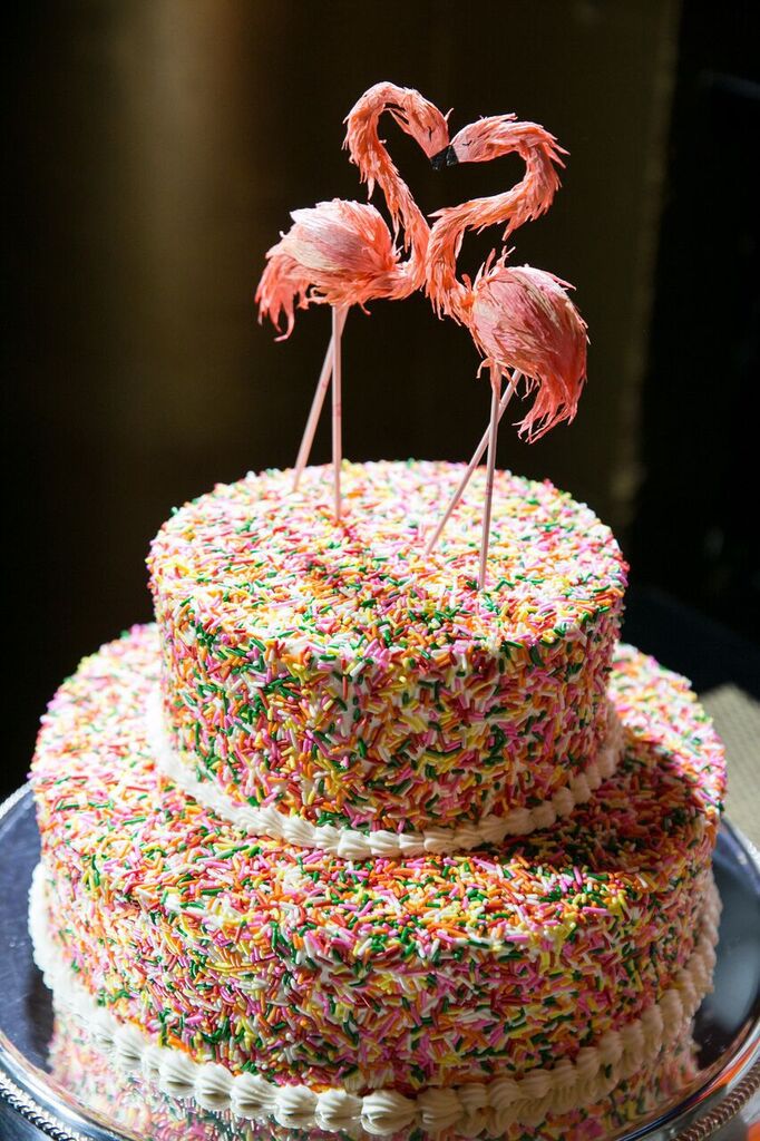 wedding cake with sprinkles and flamingo topper