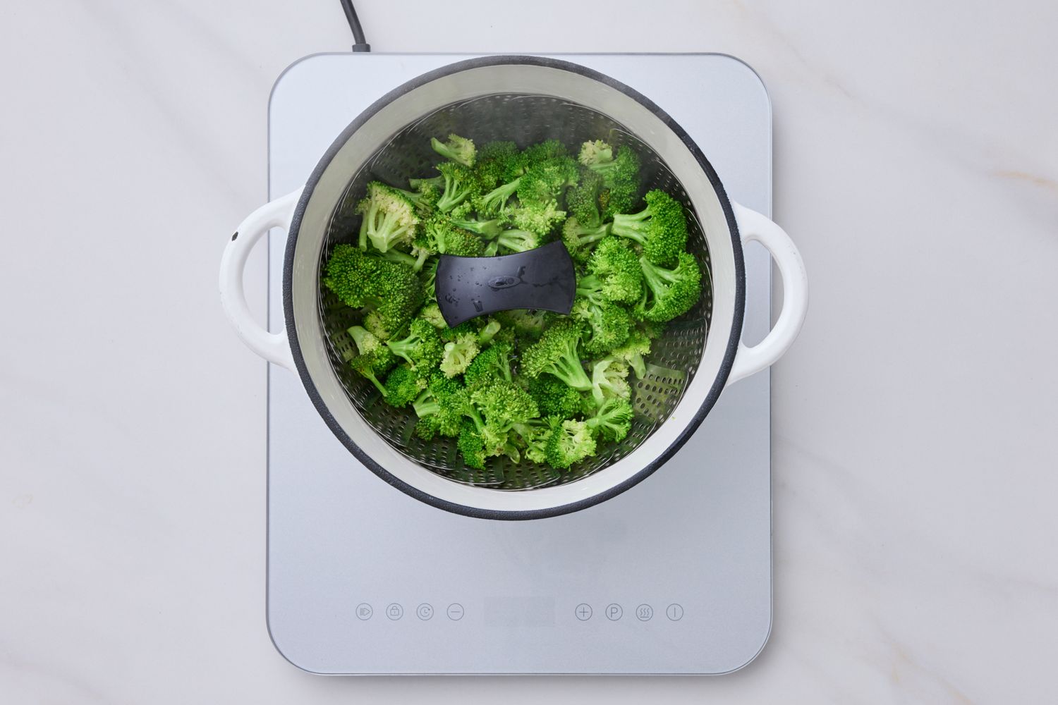 Broccoli being steamed in a pot on a stovetop