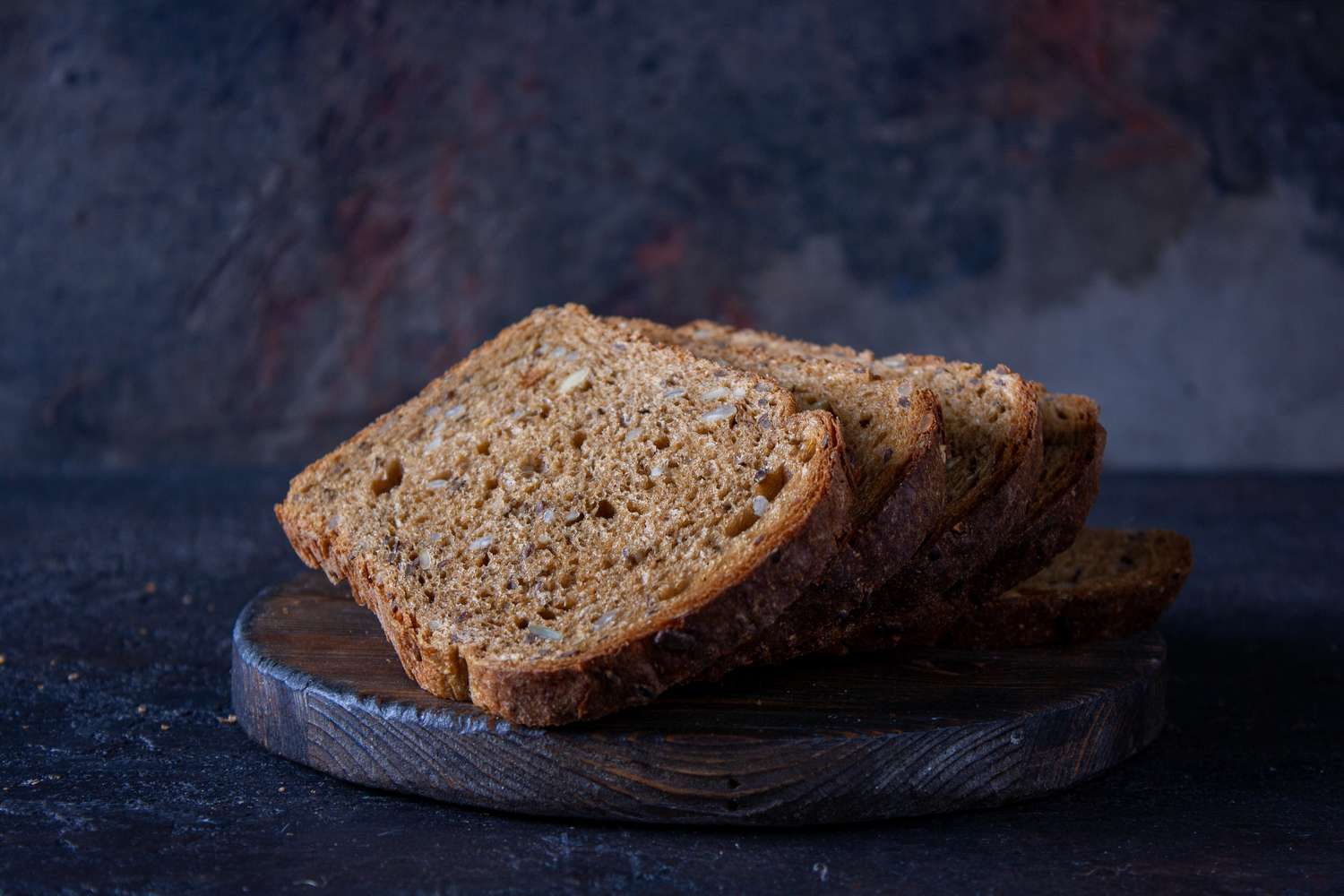slices of sprouted grain bread on a dark wooden board