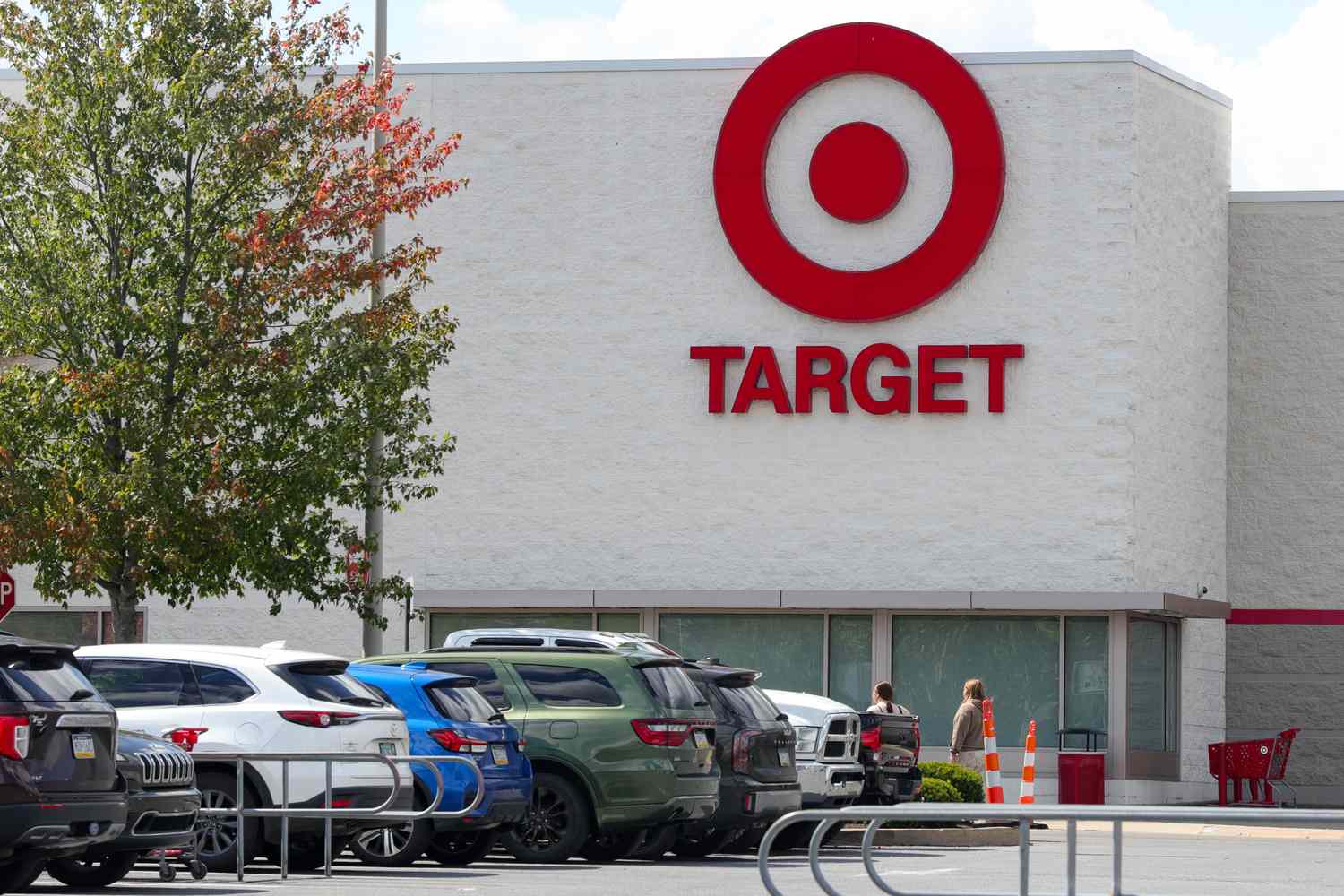Storefront of Target with parked cars and people entering the building