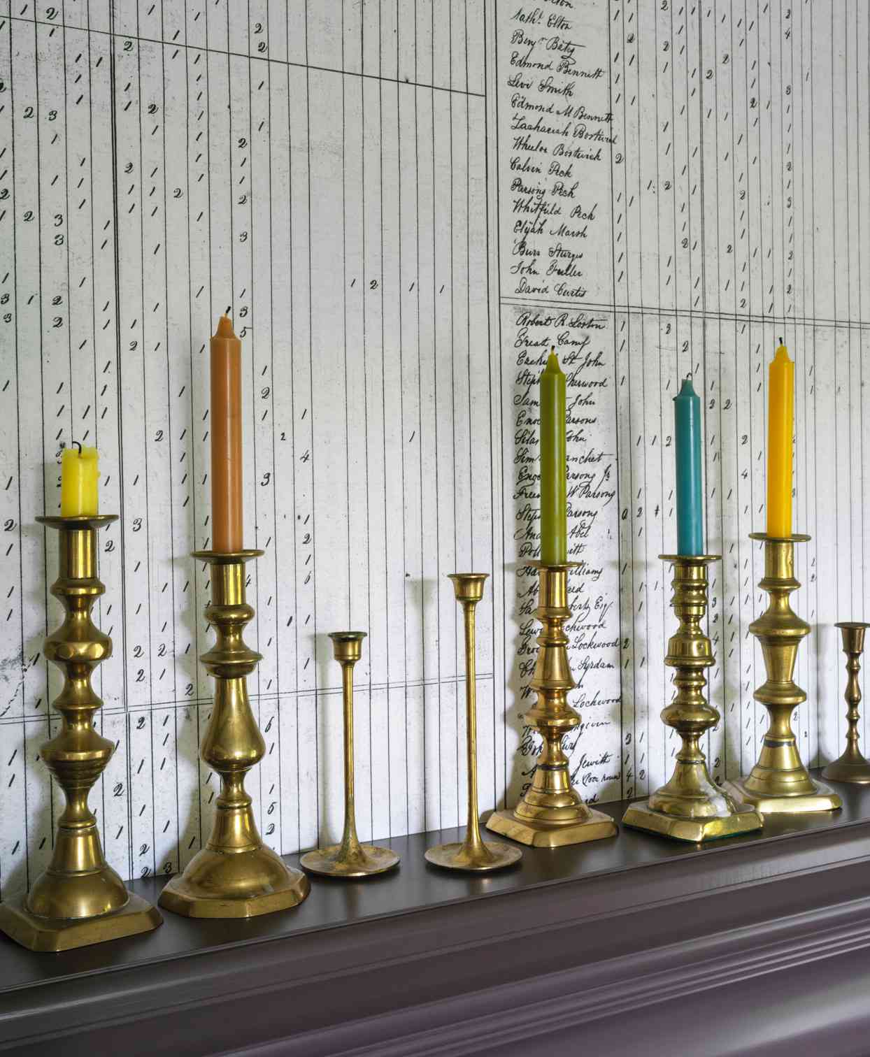brass candle stick holders holding multicolored candles