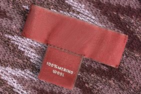 A clothing tag reading 100 merino wool on a piece of fabric