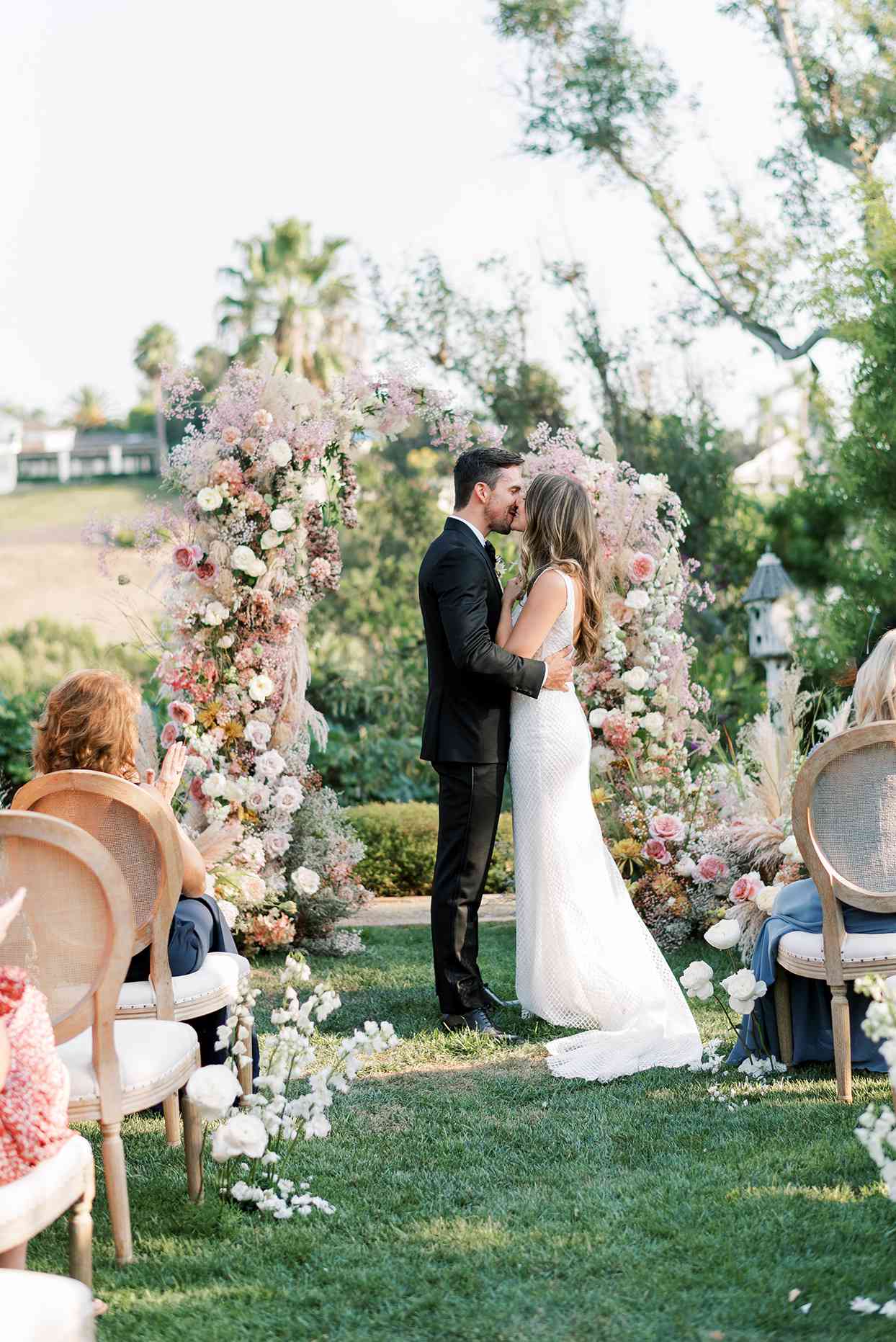 bride and groom share a kiss after backyard wedding ceremony