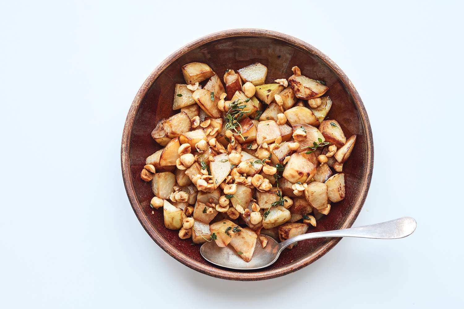 roasted kohlrabi with buttered hazelnuts in brown bowl