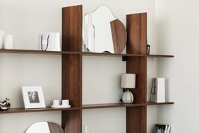 Wooden shelf display with decor items including mirrors a framed photo and candles