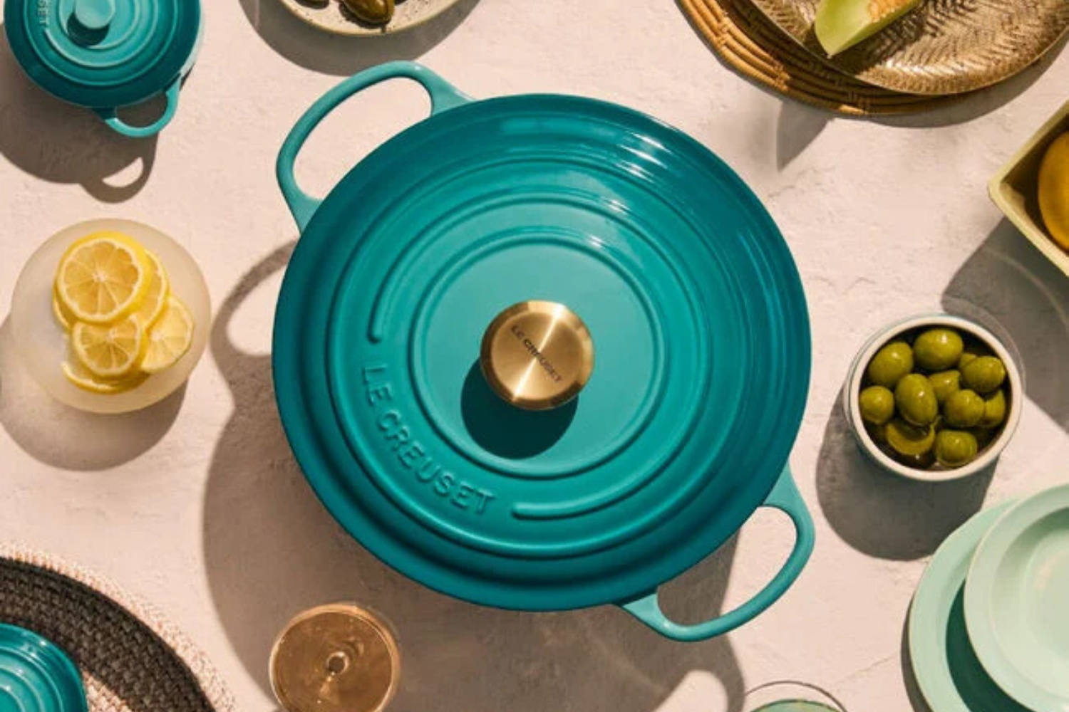 Le Creuset pot surrounded by plates with food items on a table