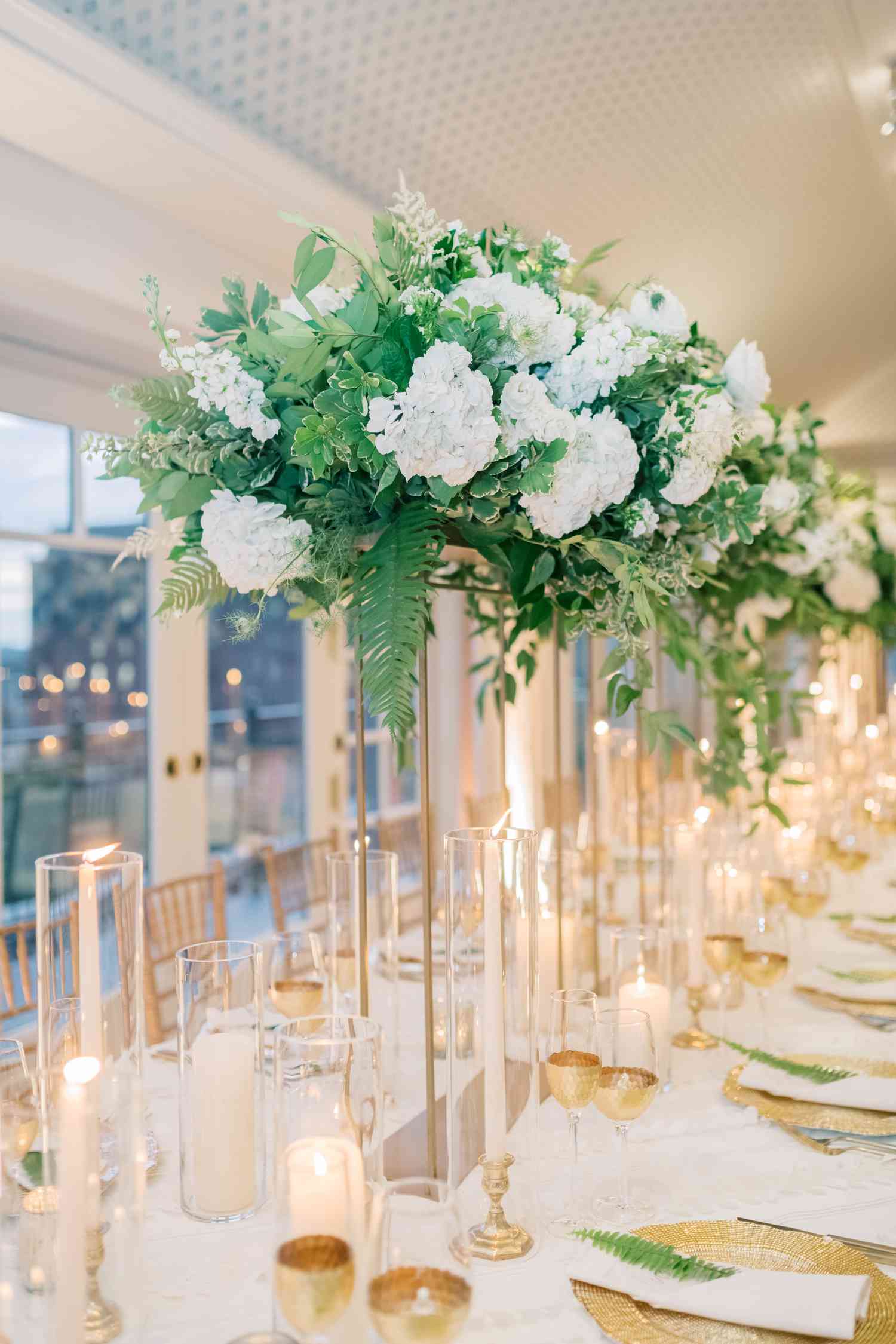 tall white and green centerpieces on gold stands
