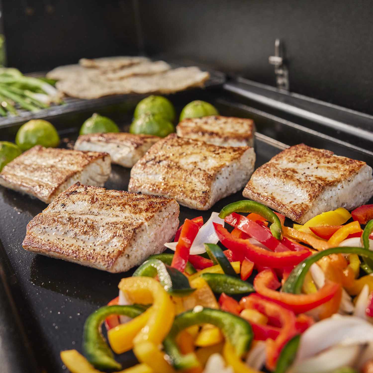 fish filets and vegetables on griddle top grill