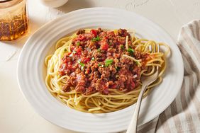 white plate of meat spaghetti sauce and pasta with fork