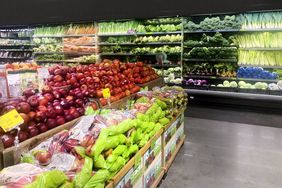 Produce section of a grocery store with fruits and vegetables displayed on shelves