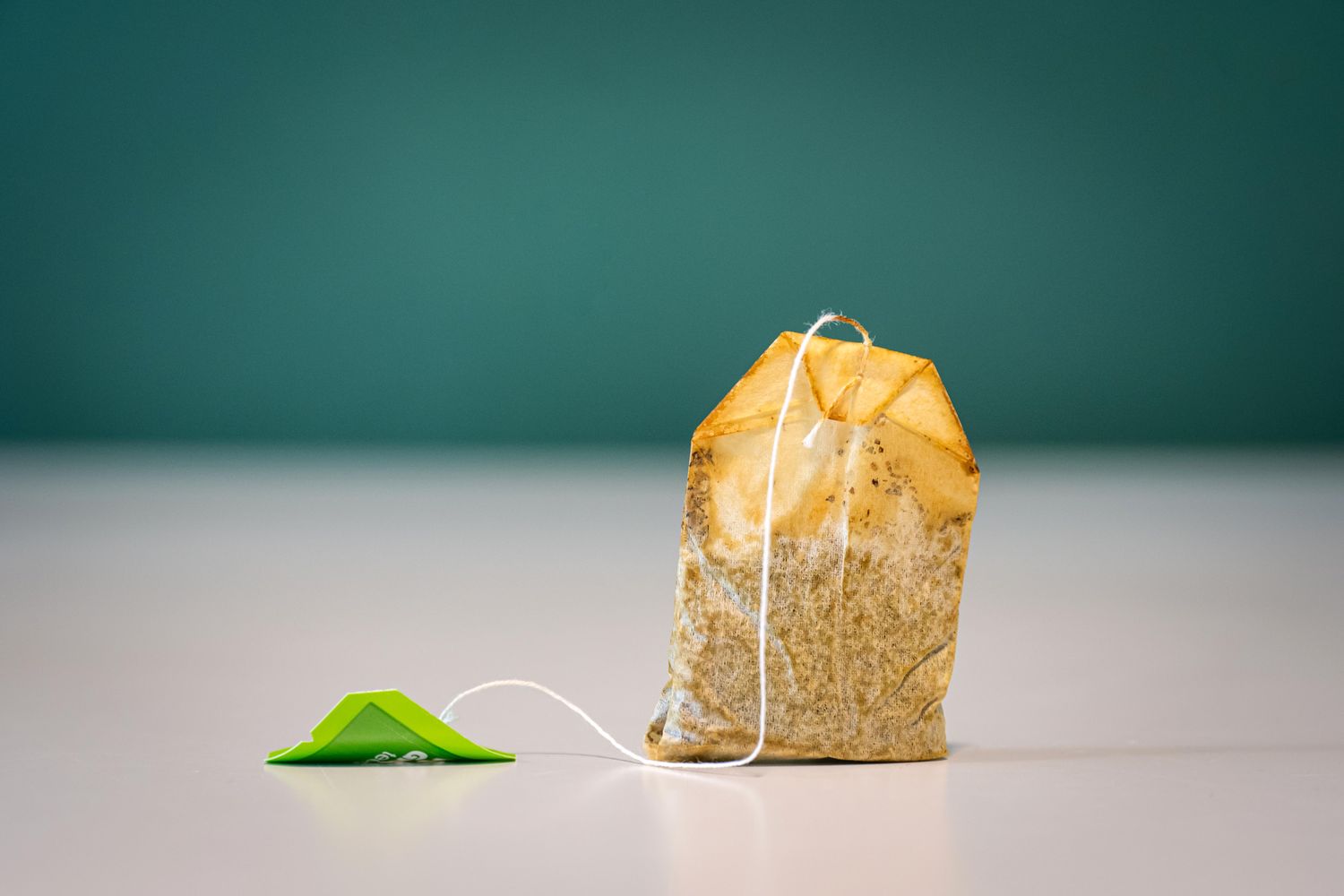 A tea bag with a string and tag on a flat surface