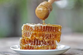 Honey dipper and honeycomb on table