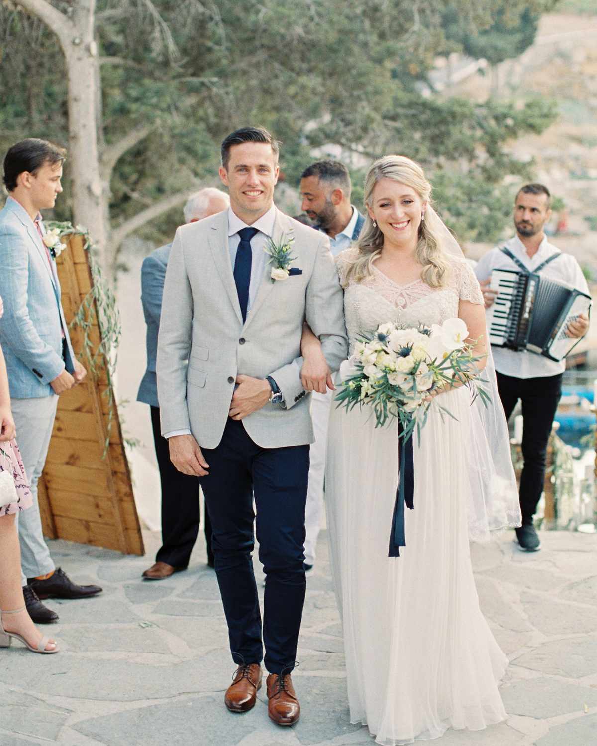 bride and groom interlocking arms walking down aisle