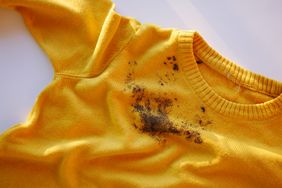 A yellow shirt with a visible dark stain on the fabric near the center