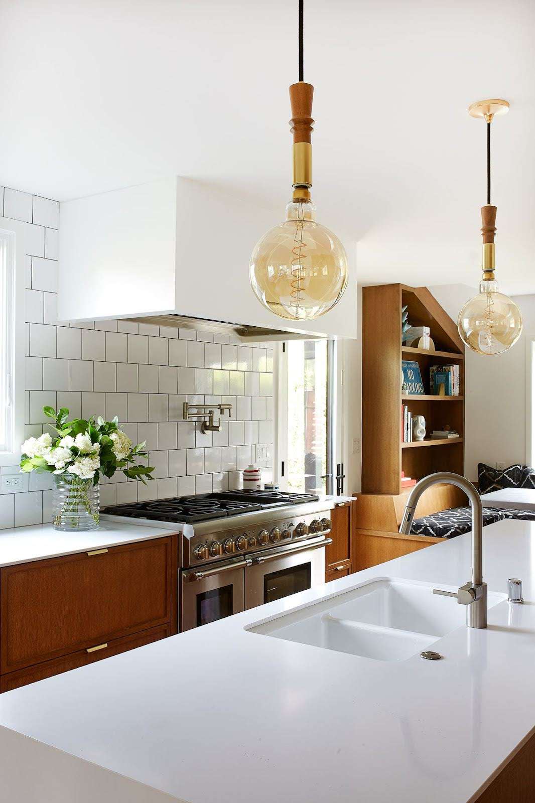 a white kitchen with pendant lights
