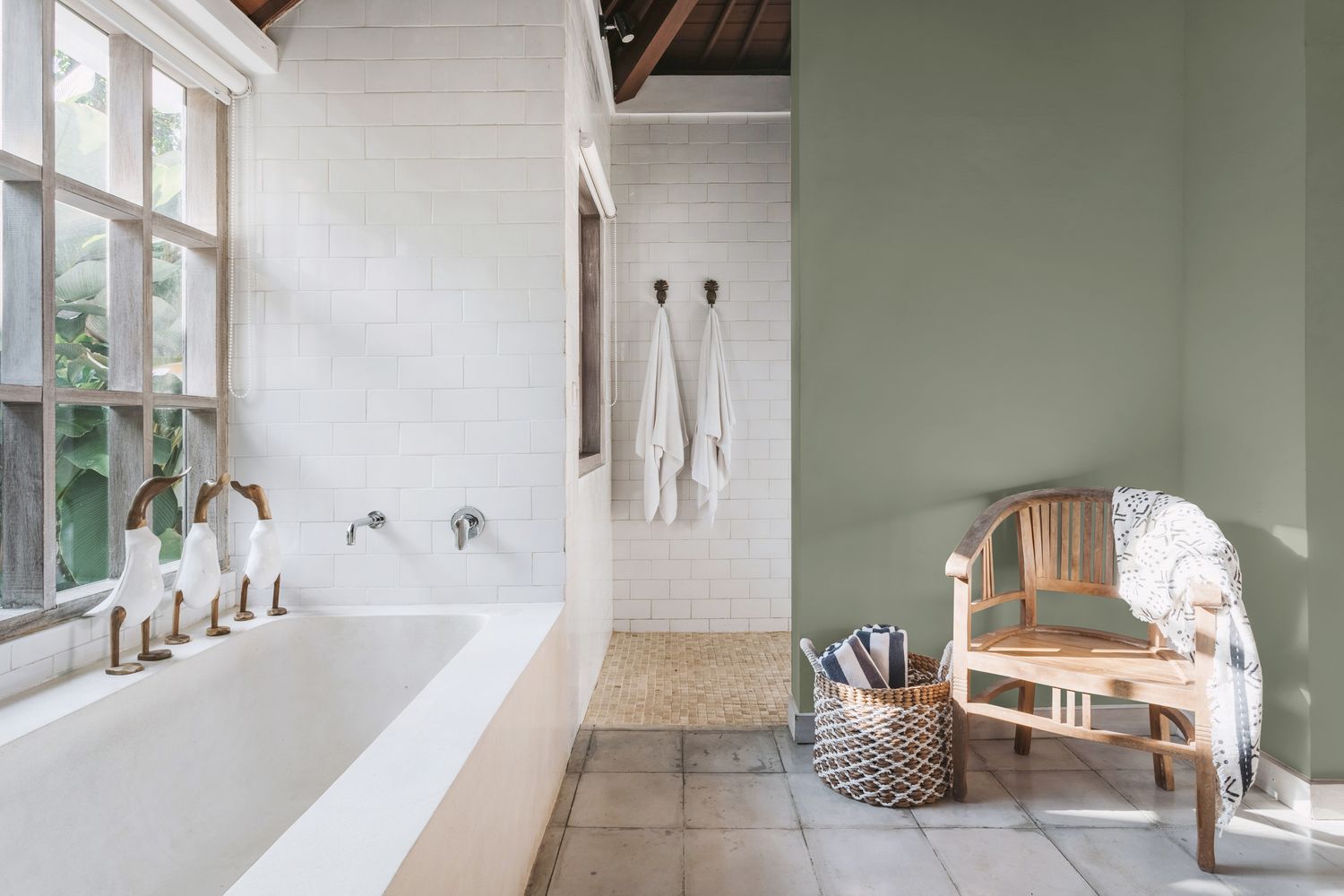 Modern bathroom with a bathtub towels and a wooden chair