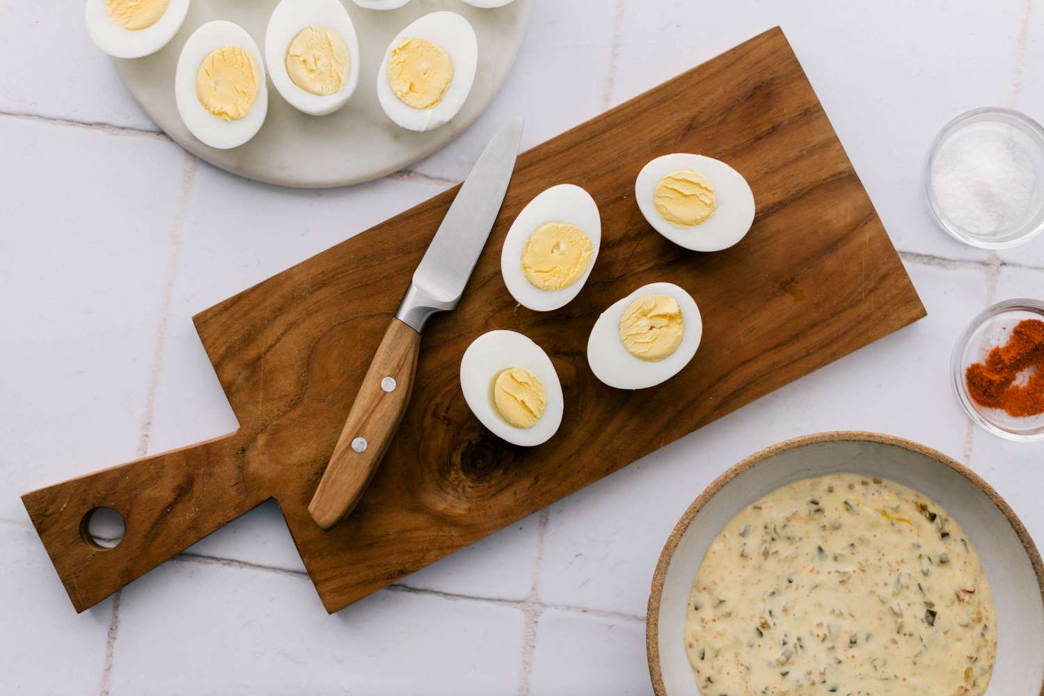 Halved hard-boiled eggs on cutting board