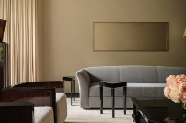 A modern living room setup with a sofa armchairs and a vase of flowers