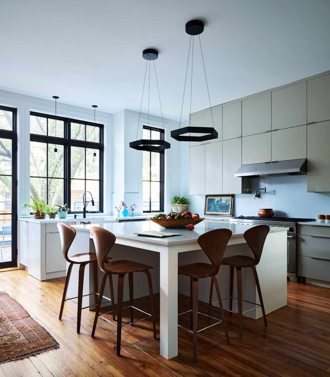 a kitchen with black pendant lights